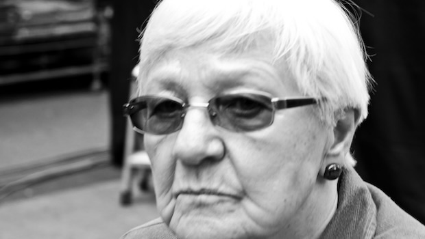 Ältere Frau mit kurzen Haaren schaut in Kamera