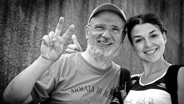 Älterer Mann und eine Frau grüßen in die Kamera.