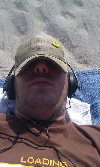 Mann mit Kappe im Gesicht udn Kopfhörern, entspannt sich