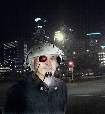 Mann mit Abtropfsieb und künstlichem Auge, vor nächtlicher Stadt