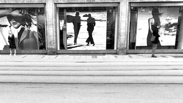 Drei Schaufenster mit Werbung