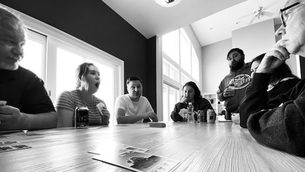 Familie sitzt am Tisch und sie reden und spielen