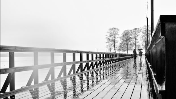 In der Ferne Paar auf Brücke im Regen