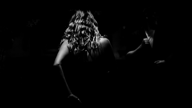 Frau mit langen Haaren und nackten Schultern im Dunkeln