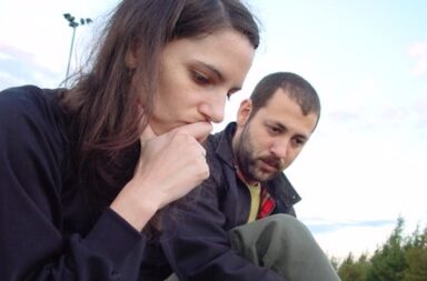 Frau und Mann sitzen im Park und überlegen