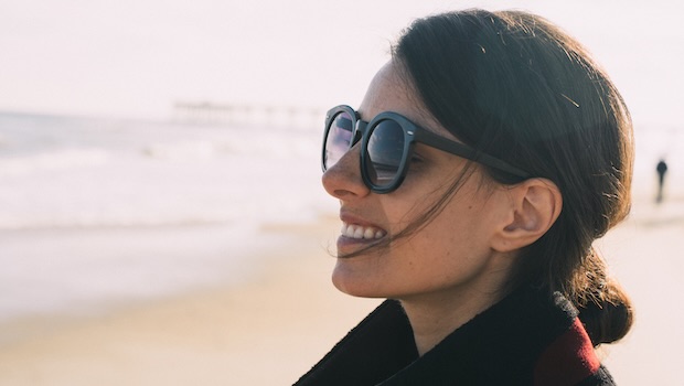 Frau mit Sonnenbrille am Strand