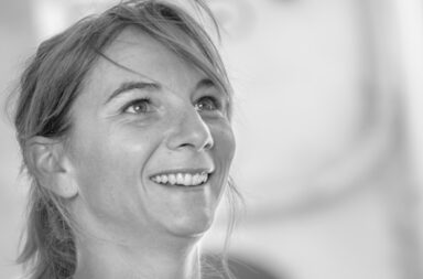 Frau mit Zopf lächelt