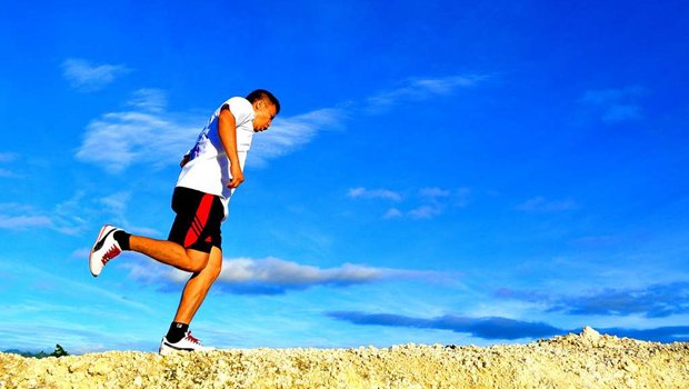 Mann joggt vor blauem Himmel