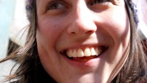 Gesicht einer jungen Frau, die breit lacht, mit weißen Zähnen