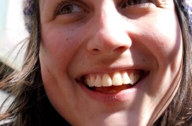 Gesicht einer jungen Frau, die breit lacht, mit weißen Zähnen