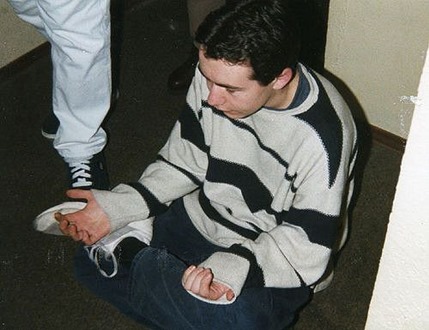 junger Mann bei Meditation im quergestreiften Pulli