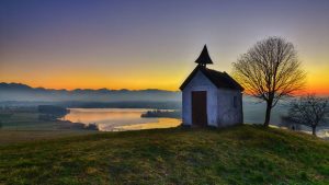 Kapelle auf Hügel vor Seelandschaft