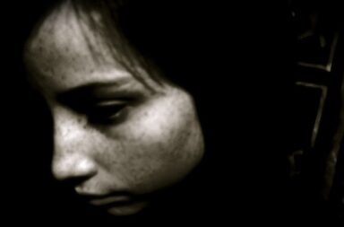 Kindergesicht traurig, dunkler Hintergrund
