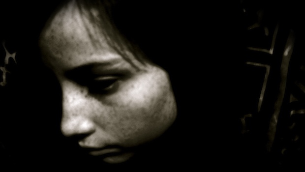 Kindergesicht traurig, dunkler Hintergrund