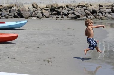 kleiner Junge, werfend am Strand