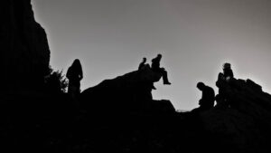 Konturen von Menschen auf Berg, sitzend und stehend