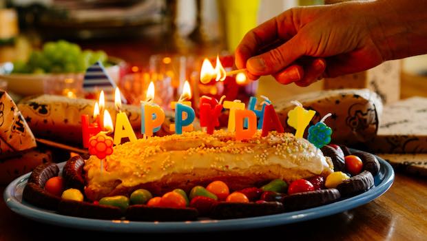 Kuchen mit Kerzen und Happy Birthday-Buchstaben
