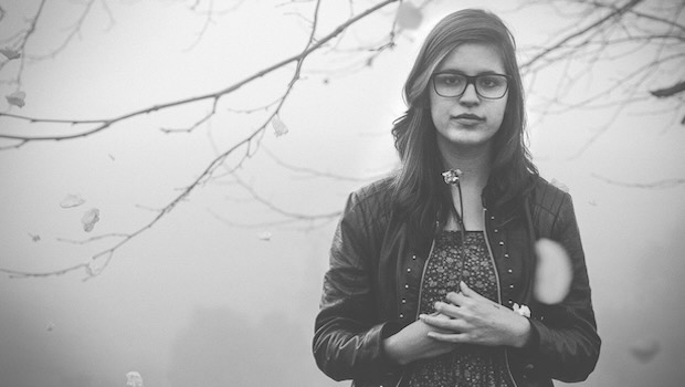 Mädchen mit Brille und Lederjacke im Nebel