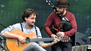 Zwei Männer mit Musikinstrumenten vor einem See