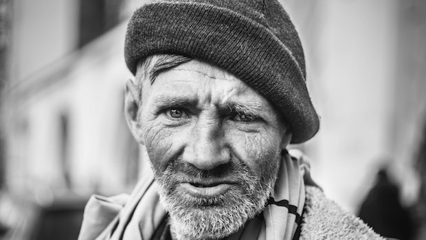 Mann mit Bart und Mütze obdachlos