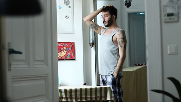 Mann in Hemd und Unterhose steht in der Wohnung