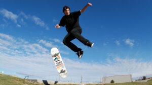 Mann springt mit Skateboard