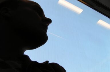 Mann im Zug schaut aus Fenster, Schattenbild