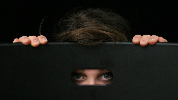 Mensch versteckt sich hinter schwarzer Box als Synonym für Leben mit emotionalem Missbrauch