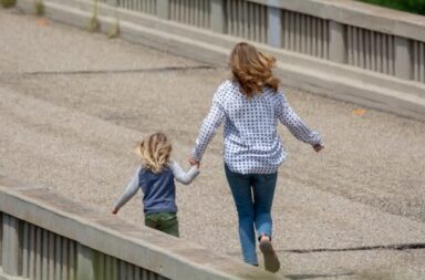 Mutter und Kind rennen über Brücke