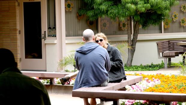 Paar auf einer Bank schaut sich an im Gespräch