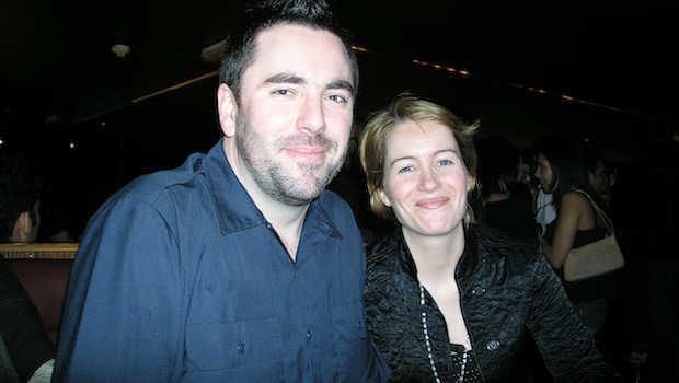 Paar sitzt in Bar und lächelt in die Kamera