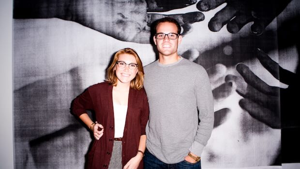 Paar steht vor Fotowand mit Händen