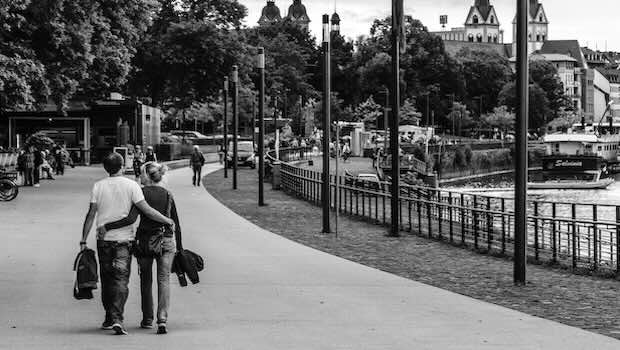 Paar geht auf Promenade am Wasser entlang.