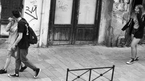 küssendes Paar auf Straße, dahinter Mädchen