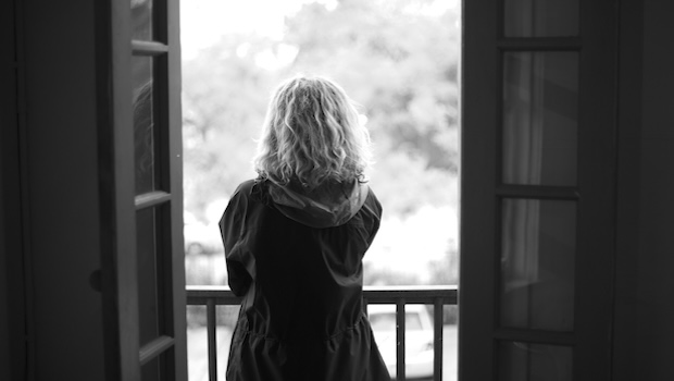 Rückansicht von Frau, die auf Balkon steht