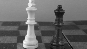 Weißer König, schwarze Dame auf Schachbrett