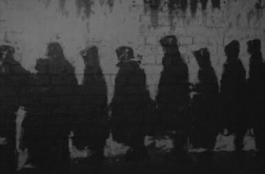 menschliche Silhouetten vor Mauer