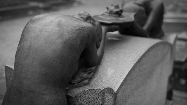 Statue gebeugt am Tisch Rückansicht