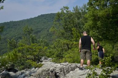 Vater mit Sohn auf einem Felsenweg im Wald