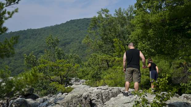 Vater mit Sohn auf einem Felsenweg im Wald