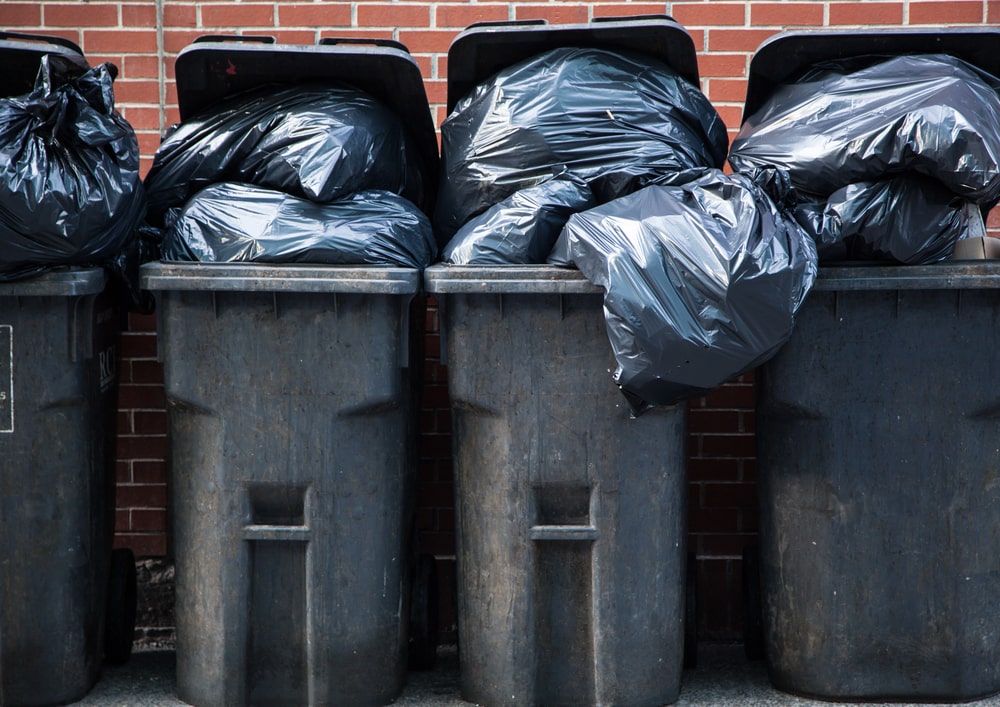 Volle Mülltonnen mit Plastiksäcken