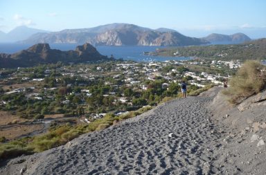 Wanderweg, Blick aufs Meer, eine Ortschaft und die Berge