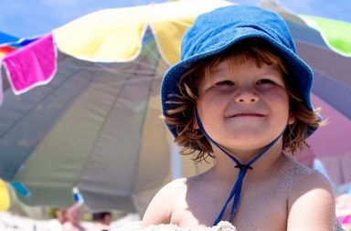 Kind am Strand mit Mütze