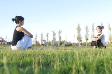 Zwei Frauen machen Yoga auf der Wiese