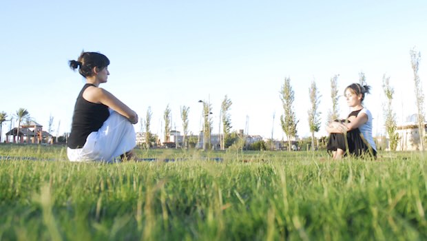 Zwei Frauen machen Yoga auf der Wiese